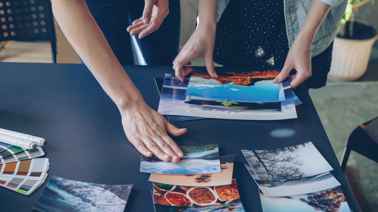 Hands arranging printed photos on a table