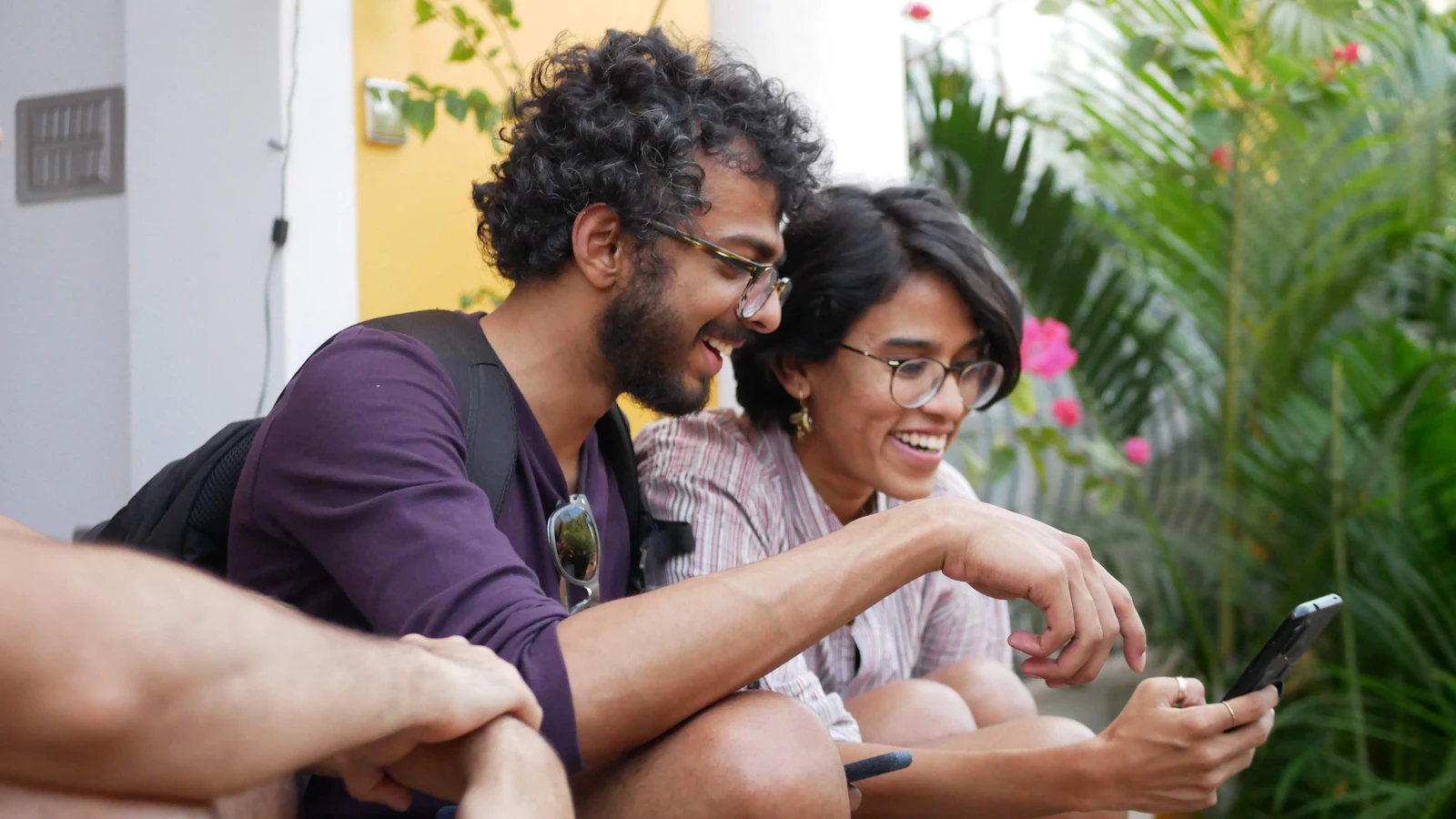 Two friends laughing at something on a smartphone