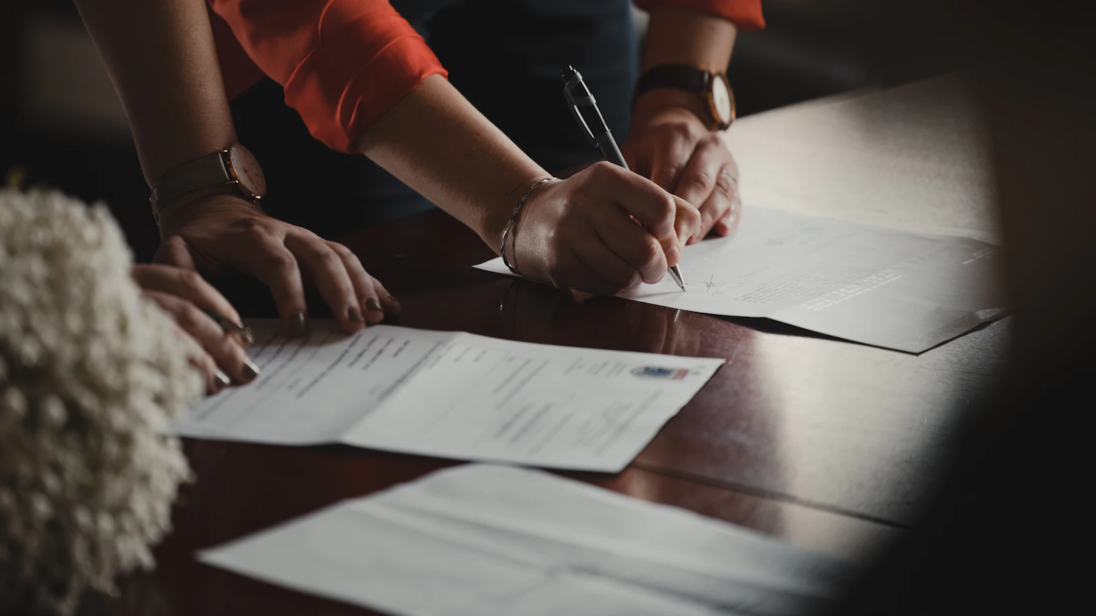 Hands signing off a document