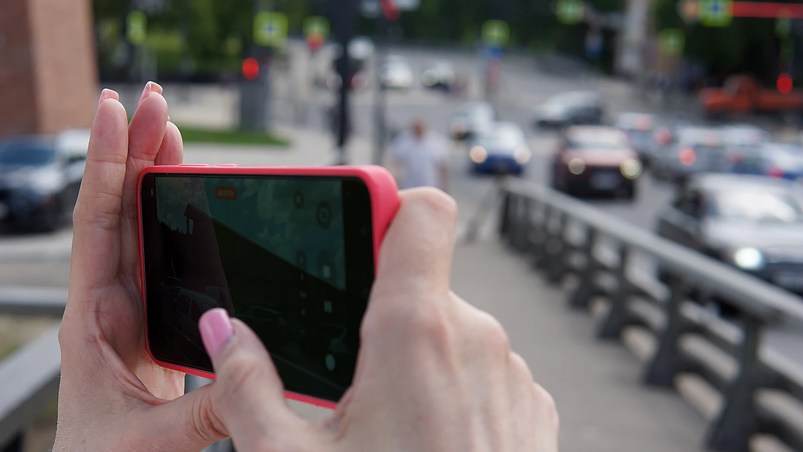 Hands recording a city street on a smartphone